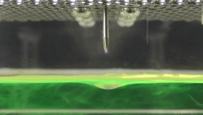 静電気の特性を利用し、水に病原体を捕捉する装置。画像は蛍光試薬を捕捉した様子