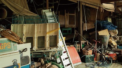 農業器具、機械、その他生活用品でごった返す作業場1階の様子。 物が多すぎて奥まで見渡せない(本文より)