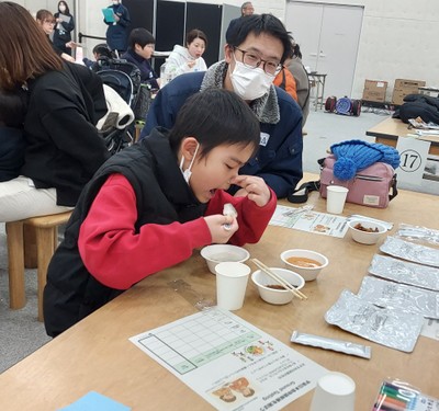 国際宇宙ステーションでの味覚を再現するため、鼻をつまんで食べている様子