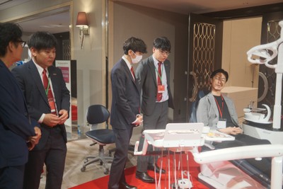 図5:営業社員から最新鋭の歯科用ユニットチェアK5(ケーファイブ)の説明を受ける参加者
