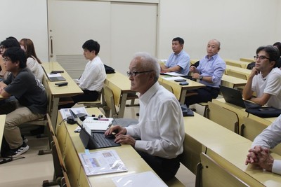 学生たちの報告に聞き入る宮下客員教授（中央）ら