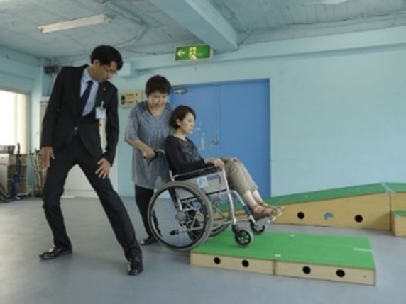 車いす使用者の介助(提供:公益財団法人日本ケアフィット共育機構)