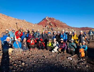 富士山の山頂付近で晴れやかな表情で写真に納まる学生たち