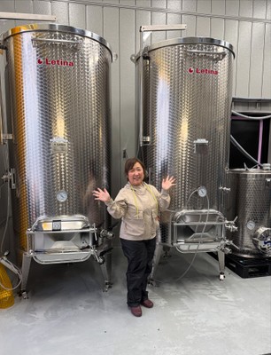 小さな身体での発酵管理は一苦労（醸造タンクの前で）
